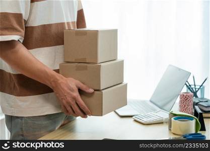 Online shopping concept the seller holding three boxes of his products to post them.