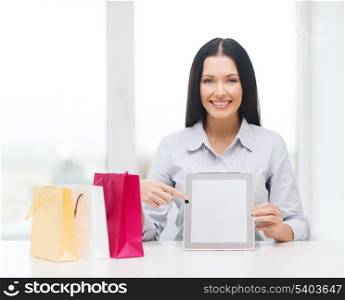 online shopping, electronics and gadget concept - smiling woman with blank screen tablet pc and shopping bags
