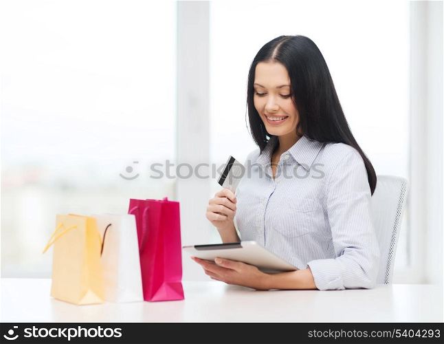 online shopping, electronics and gadget concept - smiling woman with blank screen tablet pc and shopping bags