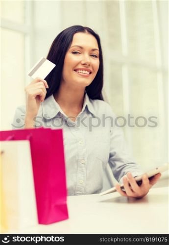 online shopping, electronics and gadget concept - smiling woman with tablet, credit card and shopping bags