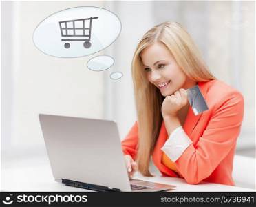 online shopping, people and technology concept - smiling young woman with laptop computer, credit card and text bubble with trolley