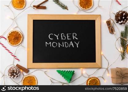 online shopping, sale and marketing concept - black chalk board with cyber monday words and christmas decorations on table. chalk board with cyber monday words on christmas