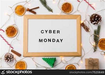 online shopping, sale and marketing concept - white magnetic board with cyber monday words and christmas decorations on table. magnetic board with cyber monday words