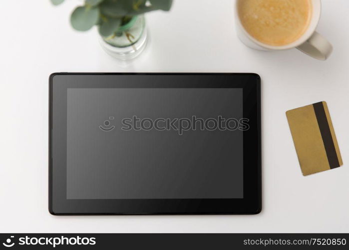 online shopping, sale and technology concept - tablet pc computer, credit card and cup of coffee on white background. tablet pc computer, credit card and cup of coffee