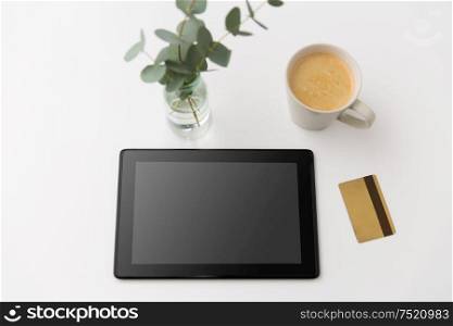 online shopping, sale and technology concept - tablet pc computer, credit card and cup of coffee on white background. tablet pc computer, credit card and cup of coffee