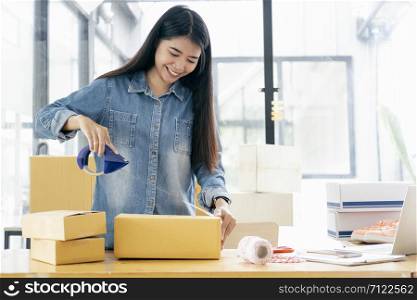 Online small business owner. Young startup entrepreneur online small business owner working at home, packaging and delivery situation.