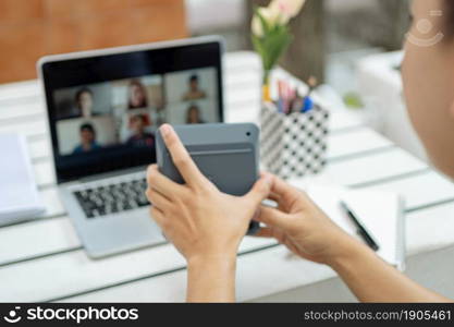 Online studying concept the man in plain white T-shirt feeling quite happy and holding the calculator for calculating numbers in accounting class.