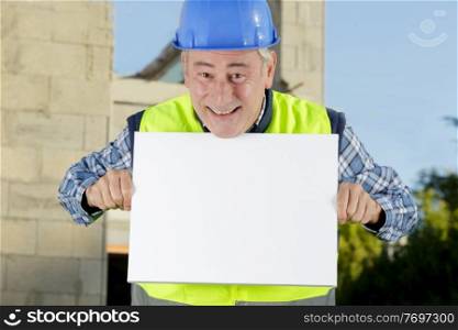 onstruction worker with protective hardhat and gloves showing blank banner