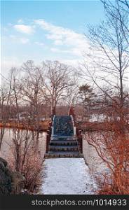 Onuma Koen Quasi -National park nature trail bridge in peaceful cold winter with dried leafless tree. Hakodate, Hokkaido - Japan.
