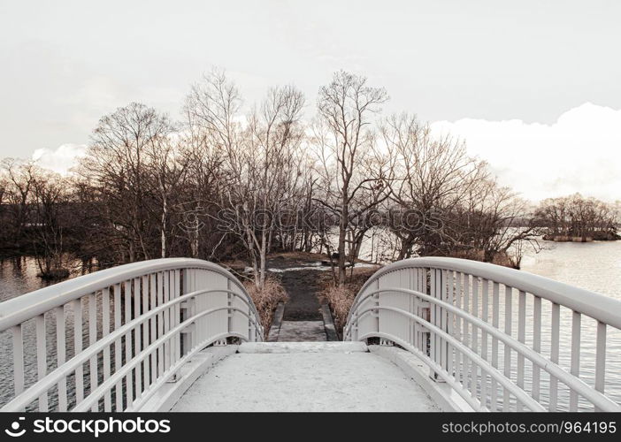 Onuma Koen Quasi -National park nature trail bridge in peaceful cold winter with dried leafless tree. Hakodate, Hokkaido - Japan.