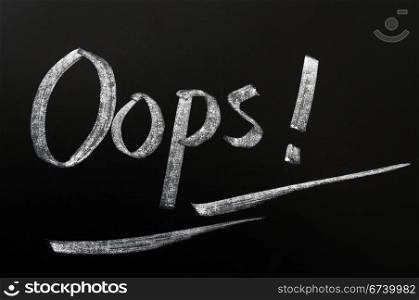 Oops with an exclamation mark written in chalk on a blackboard