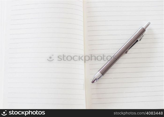 Open a blank white notebook and pen , stock photo