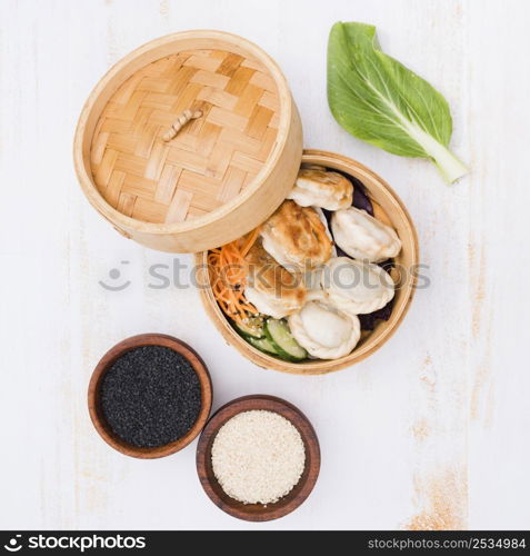 open bamboo steamers with dumplings sesame seeds textured backdrop