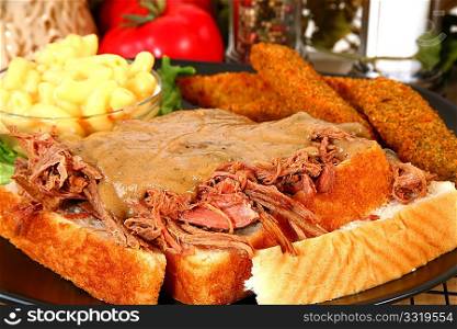 Open beef sandwich with gravy, macaroni and fried pickles.
