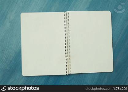 Open blank notebook on a wooden blue background