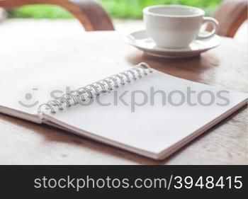 Open blank white notebook with cup of coffee, stock photo