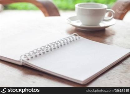 Open blank white notebook with cup of coffee, stock photo