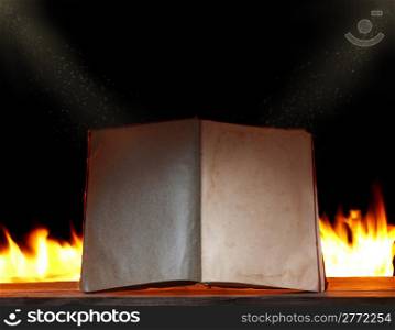 open book in ambient light with fire on background