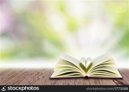 Open book on white, over abstract light background.. Open book