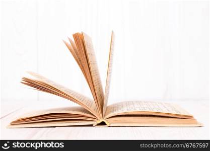 Open book on white wood background. With place for text