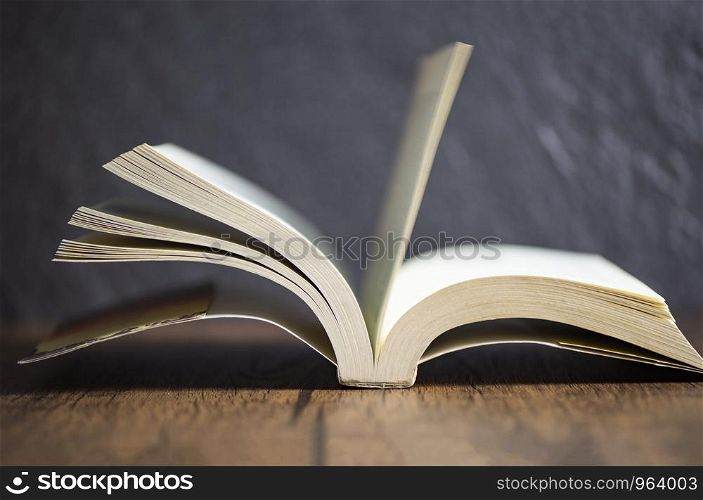 open book vintage on old wooden table dark background at library education concept