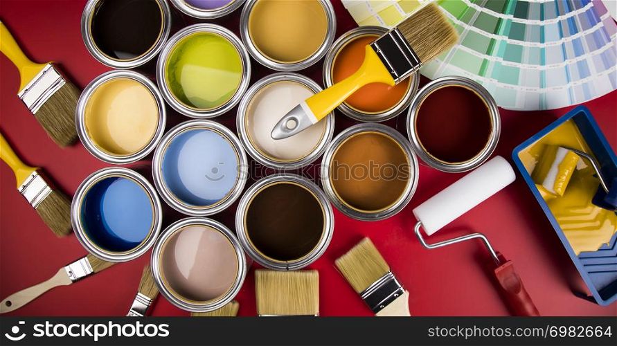 Open buckets with a paint and brush, red background