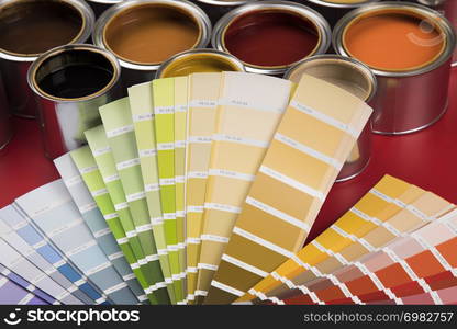 Open buckets with a paint and brush, red background