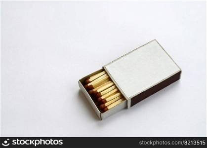 Open cardboard matchbox filled with matches on a white background. Flat lay minimal. Top view with text space. Open cardboard matchbox filled with matches on a white background