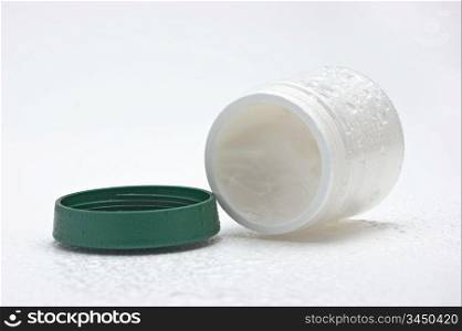open cosmetic cream jar wet