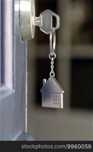 Open door to a new home with key and home shaped keychain. Mortgage, investment, real estate, property and new home concept business. Open door to a new home with key and home shaped keychain. Mortgage, investment, real estate, property and new home concept