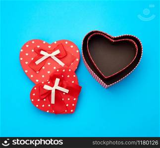 open empty red cardboard box in the form of a heart on a light blue background, top view, element for a designer