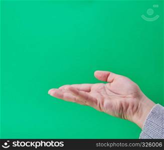 open female hand, gesture of holding the subject, green background
