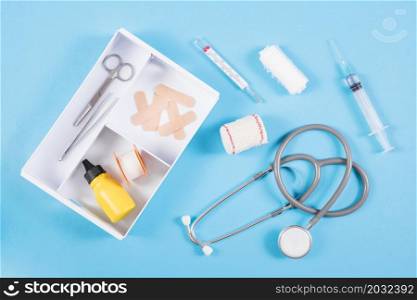 open first aid kit with medical equipments blue background