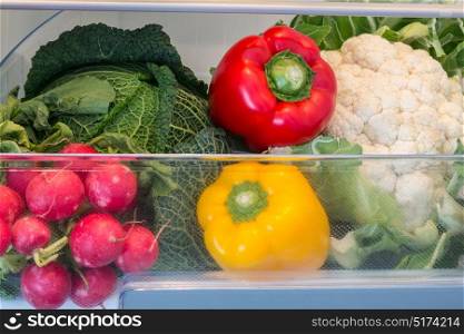 Open fridge filled with fruits and vegetables.. Open fridge filled with fruits and vegetables