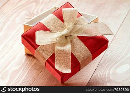 Open gift box with golden ribbon and bow