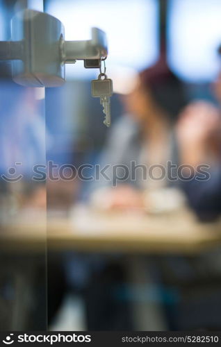 Open glass door with keys, key in keyhole