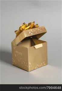 Open Golden gift box with golden ribbon on gray background