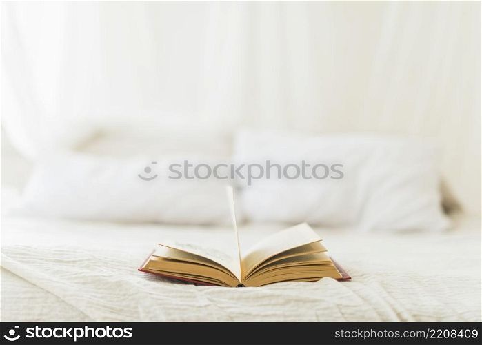 open hardcover book bed home
