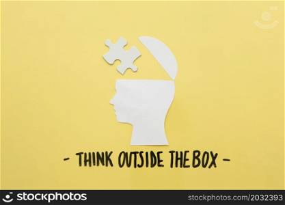open human brain with jigsaw piece near think outside box message