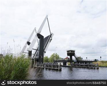 open modern drawbridge near Sneek in dutch province of friesland on overcast day in early summer