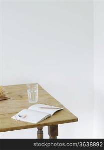 Open notebook and glass of water on table