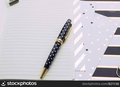 Open notebook in line, pen and different sheets with gold pattern