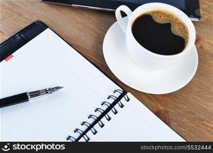 open notebook, pen and cup of coffee