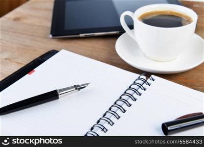 open notebook, pen and cup of coffee