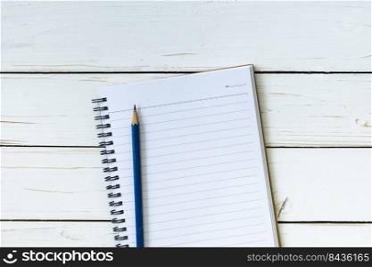 Open notebook with blank pages and pencil