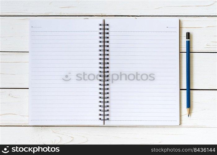 Open notebook with blank pages and pencil on wood table