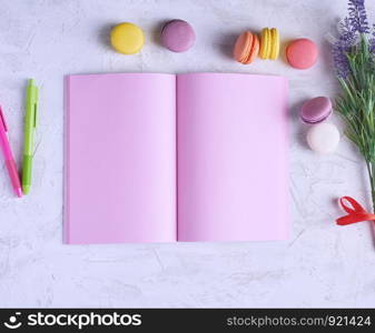 open notebook with blank pink pages, red, green pencil and a bouquet of lavenders on a white background, top view, flat lay