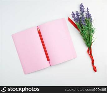 open notebook with blank pink pages, wooden red pencil and a bouquet of lavenders on a white background, top view, flat lay