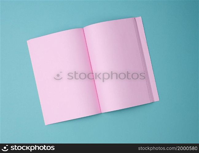 open notebook with blank pink sheets on blue background, top view