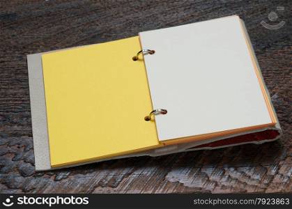 Open Notebook with yellow page on wooden background